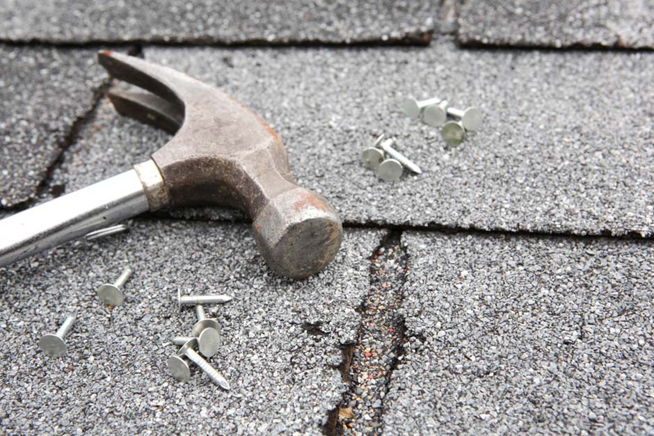 close up of roof shingles and hammer and nails used during a roof replacement