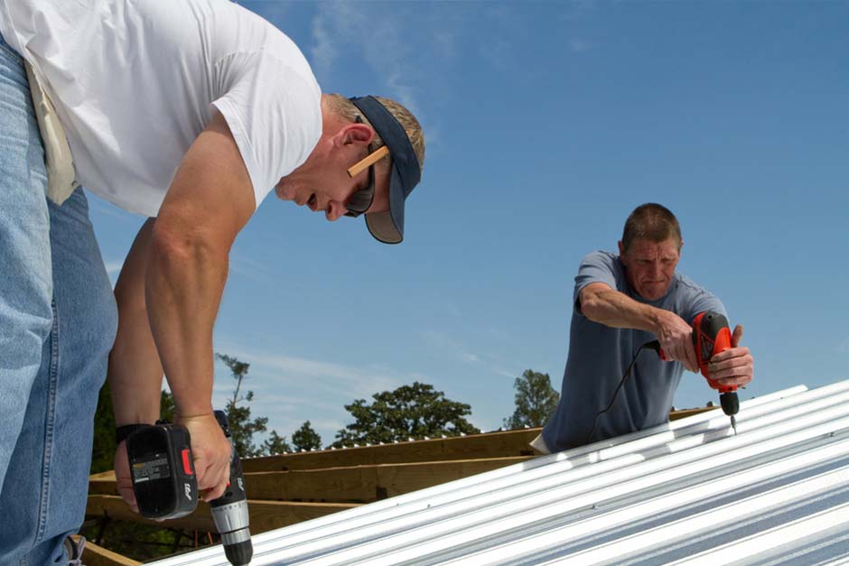 Two men working on sheet metal roofing