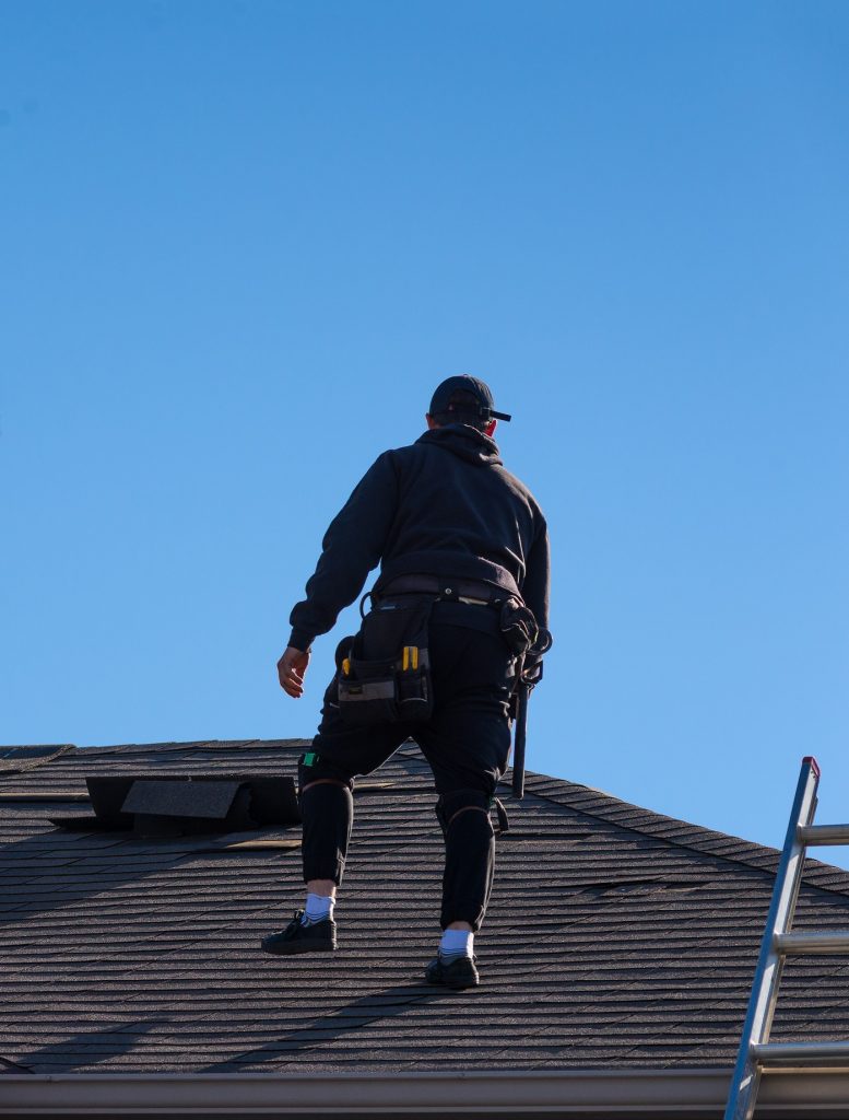 Roofer evaluating roof for roof restoration vs roof replacement
